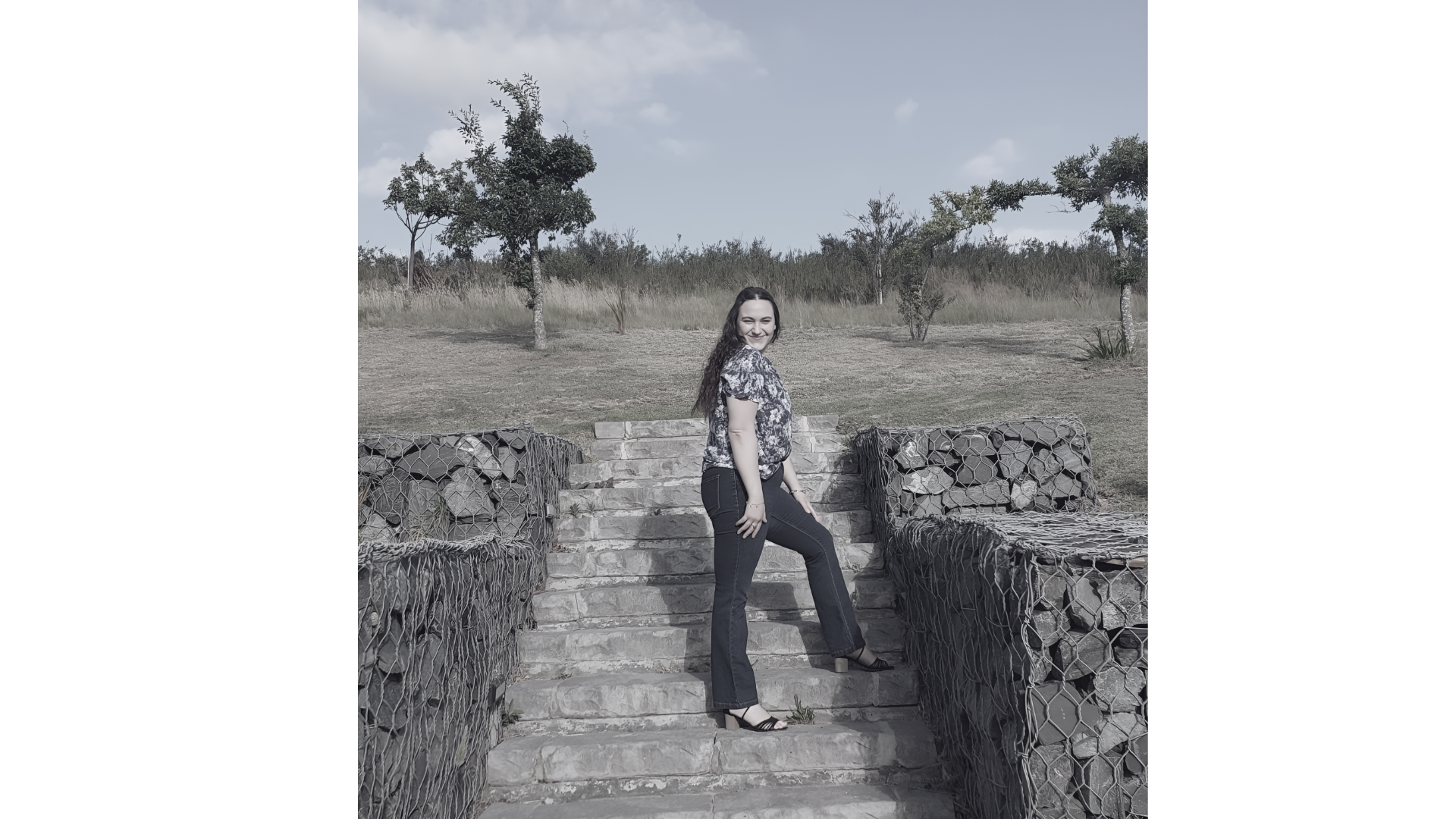 Simoné, founder of Simatrix Digital Studios, standing on stone steps outdoors